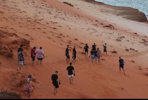 a group of people walking on a beach at POUSADA CENÁRIO IDEAL in Icapuí