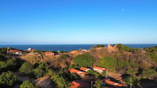 a group of houses on a hill next to the ocean at POUSADA CENÁRIO IDEAL in Icapuí