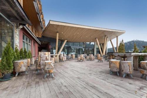 Un patio con mesas y sillas frente a un edificio. en Private Apartment Lora - Aparthotel Vučko, en Jahorina