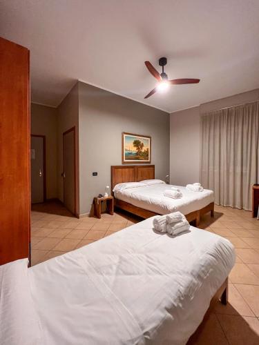 a bedroom with two beds and a ceiling fan at Convento Boutique Hotel in Susa