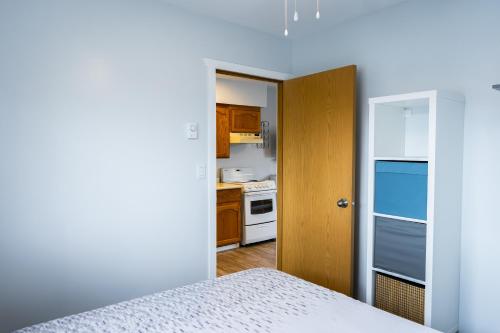 a room with a bed and a kitchen at Poplars Motel on the lake in Osoyoos