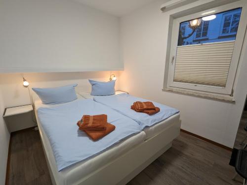 - une chambre avec un lit et 2 serviettes dans l'établissement Haus Ekke Nekkepenn I, Whg 3, à Wyk auf Föhr