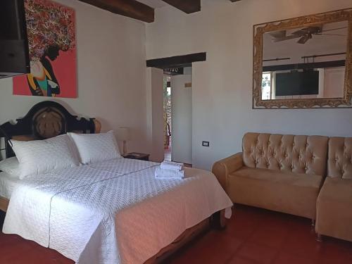 a bedroom with a bed and a couch at EMMA HOTEL SAN DIEGO in Cartagena de Indias