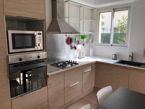 y cocina con fogones y microondas. en Maison confortable et calme/5 chambres & 6 SdB, en Toulouse