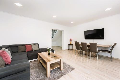 a living room with a black couch and a table at Casa Beaumont Cristian in Cristian