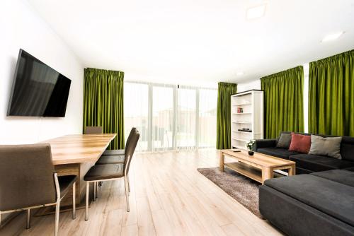 een woonkamer met een tafel en groene gordijnen bij Casa Beaumont Cristian in Cristian