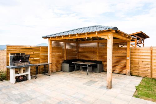 a wooden pergola with a table and a grill at Casa Beaumont Cristian in Cristian