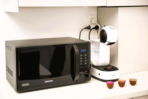 a microwave sitting on a counter next to a coffee maker at Casa Beaumont Cristian in Cristian