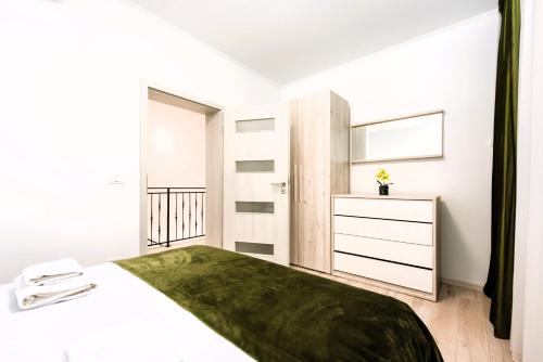 a white bedroom with a bed and a dresser at Casa Beaumont Cristian in Cristian