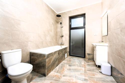 a bathroom with a toilet and a tub and a sink at Casa Beaumont Cristian in Cristian