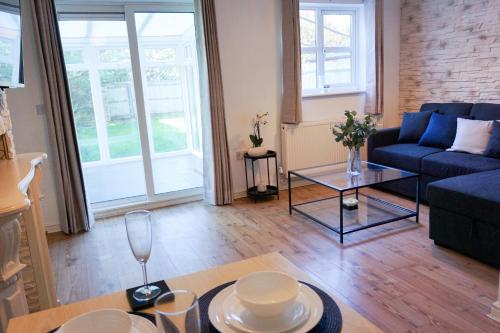 een woonkamer met een bank en een tafel bij Oak House - Spacious Townhouse, FREE gated parking, perfect for corporate, contractor & Leisure guests in Bedford