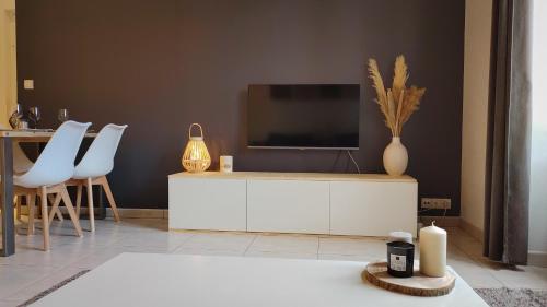 una sala de estar con TV en un armario blanco en La Suite Côté Parc (Superbe T2 classé 4*) en Saint-Martin-dʼUriage