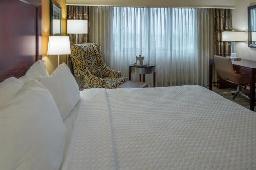 a hotel room with a large bed and a desk at Crowne Plaza Hotel St. Louis Airport by IHG in Bridgeton