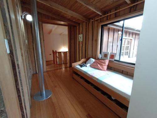um quarto com uma cama e uma grande janela em Hostal Repu em Pucón