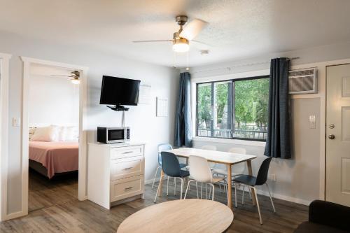 a room with a bed and a table and chairs at Poplars Motel on the lake in Osoyoos