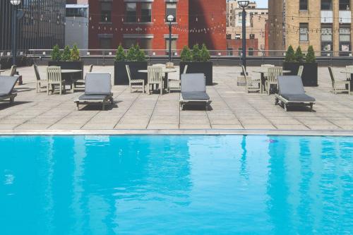 a pool with chairs and tables and a table and chairs at Renaissance Columbus Downtown Hotel in Columbus