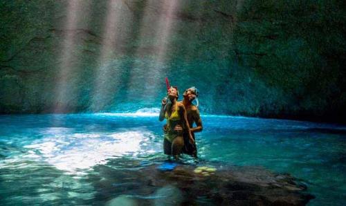 two people standing in the water under a rainbow at Tanna Lava View Bungalows in Lénakel
