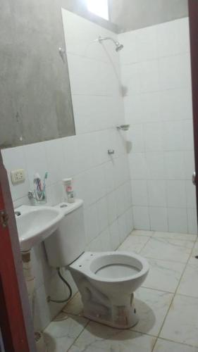 y baño con aseo y lavamanos. en Casitas Rurales Las Palmeras, en Yurimaguas