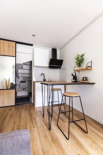a kitchen with a table and stools in a room at Studio 63 in Roissy-en-Brie