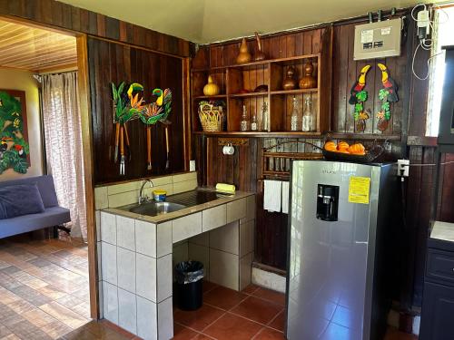 a kitchen with a refrigerator and a sink at Cabaña en Alajuela en lugar tranquilo y con mucha naturaleza. in Tambor