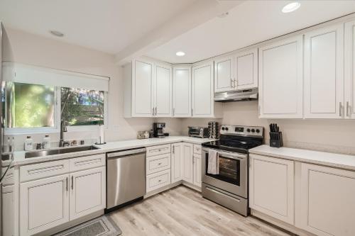 a white kitchen with white cabinets and appliances at 2-1 San Diego Getaway Home Near Major Attractions in San Diego