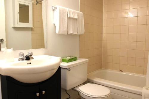 a bathroom with a sink and a toilet and a tub at Midtown Inn in Saskatoon