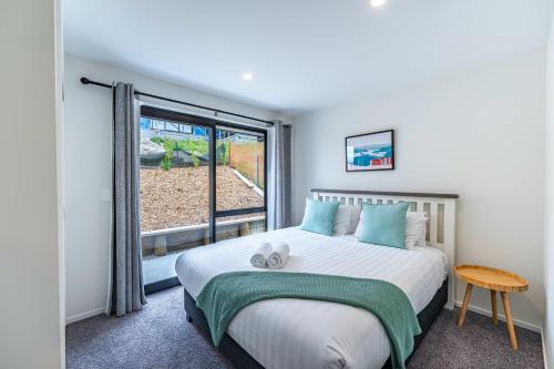 a bedroom with a large bed and a window at Kirimoko Family Retreat in Wanaka