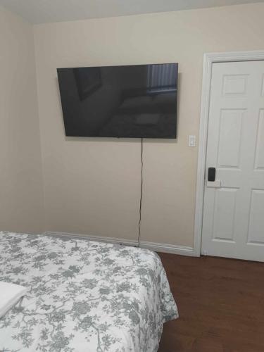 a bedroom with a flat screen tv on the wall at Hidden Gem in South Gate