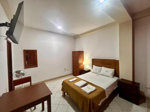 HOTEL LOS ANDES SUITE في تروخيو: غرفة نوم بسرير وطاولة ومكتب
