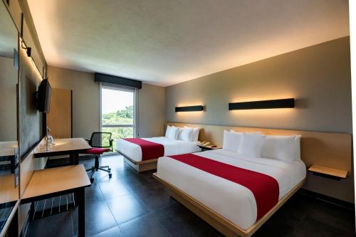 Habitación de hotel con 2 camas y escritorio en City Express Plus by Marriott Cali Colombia, en Cali