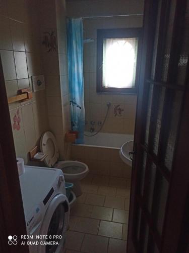 y baño con aseo, bañera y lavamanos. en Appartamento Bersani en CastellʼArquato