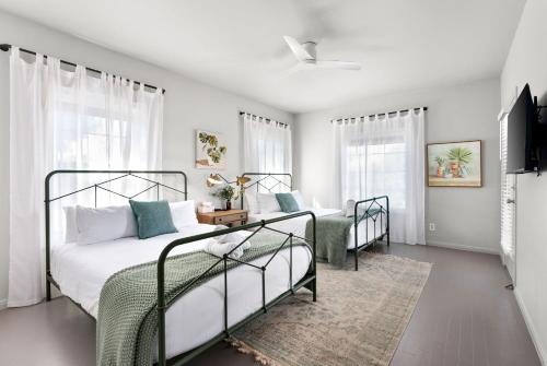 a bedroom with two beds and a couch and windows at Hot Tub + Fire Pit + Pool + Game Room ~ Guesthouse in Manor