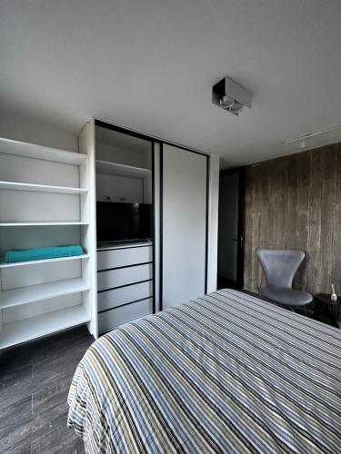 - une chambre avec un lit et une chaise dans l'établissement Casa del cerro 1 - Three Houses, à La Rioja