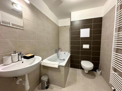 La salle de bains blanche est pourvue d'un lavabo et de toilettes. dans l'établissement Sky Apartments 505, à Plzeň