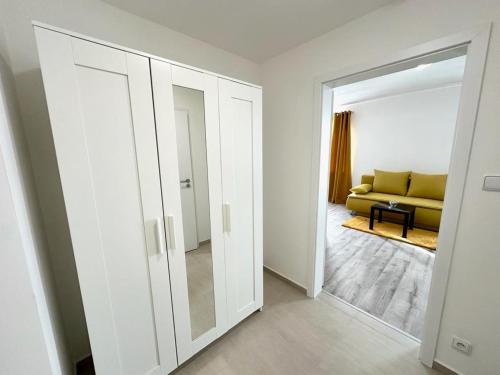 - un salon avec un canapé jaune et un miroir dans l'établissement Sky Apartments 505, à Plzeň