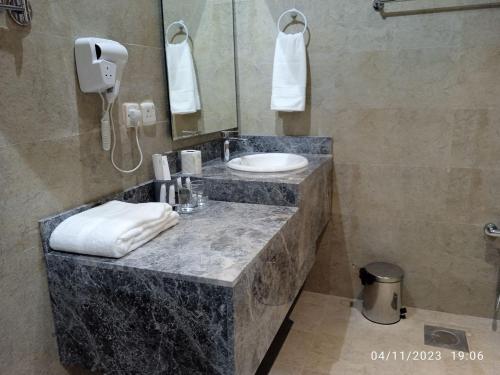 a bathroom with a counter with a sink and a mirror at الماسةالتاج للشقق الفندقية in Hail