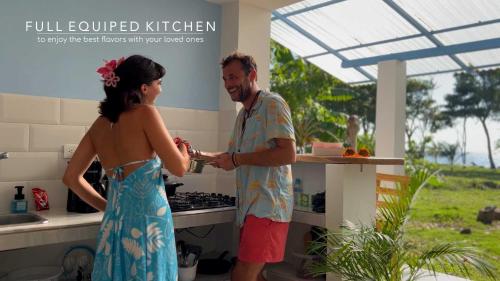a man and a woman standing in a kitchen at Beach House with AC Surrounded by Nature in Moñitos