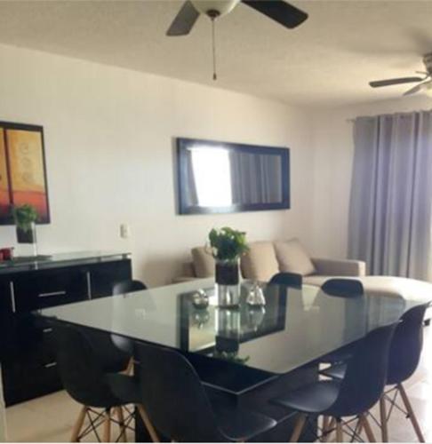 a dining table and chairs in a living room at Oceanfront white sand beach condo for families in Cancún