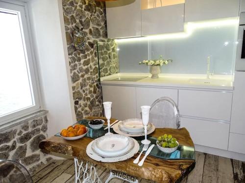 a kitchen with a table with plates and fruit on it at Casa Vela in Cefalù