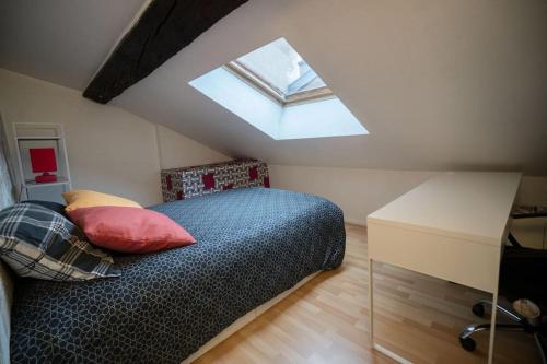 ein Schlafzimmer mit einem Bett und einem Dachfenster in der Unterkunft Cosy and calm apartment in the center of nancy in Nancy