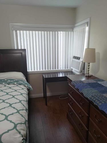 a bedroom with a bed and a desk and a window at Secluded Gem in South Gate