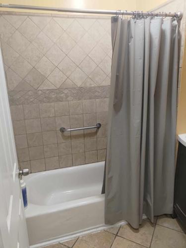 a bathroom with a tub and a shower curtain at Secluded Gem in South Gate