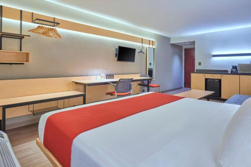 a hotel room with a large bed and a kitchen at City Express by Marriott Hermosillo in Hermosillo