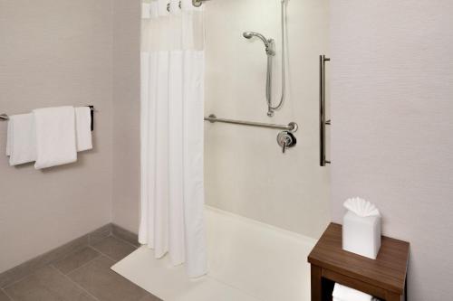 W łazience znajduje się prysznic z zasłoną prysznicową. w obiekcie Courtyard by Marriott Stamford Downtown w mieście Stamford