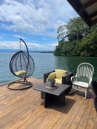 a patio with a swing and a table and chairs at Ponci’s Gate to Gaia Holistic Center in Bocas del Toro