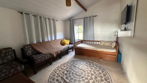 a small living room with a couch and a chair at Chácara Bela Vista in Paraibuna