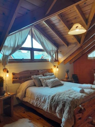 1 dormitorio con 1 cama grande y ventana grande en Tierras del Sur II en Villa La Angostura