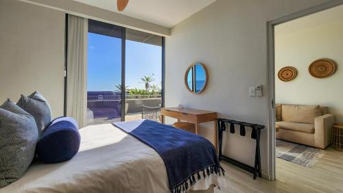 a bedroom with a bed with a view of a balcony at Infinity LG8 Beachfront Apartment in Bloubergstrand