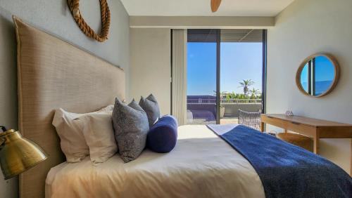 a bedroom with a bed with pillows and a mirror at Infinity LG8 Beachfront Apartment in Bloubergstrand