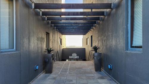 a hallway with two potted plants in a building at Infinity LG8 Beachfront Apartment in Bloubergstrand